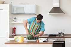 Mann zerteilt eine Wassermelone