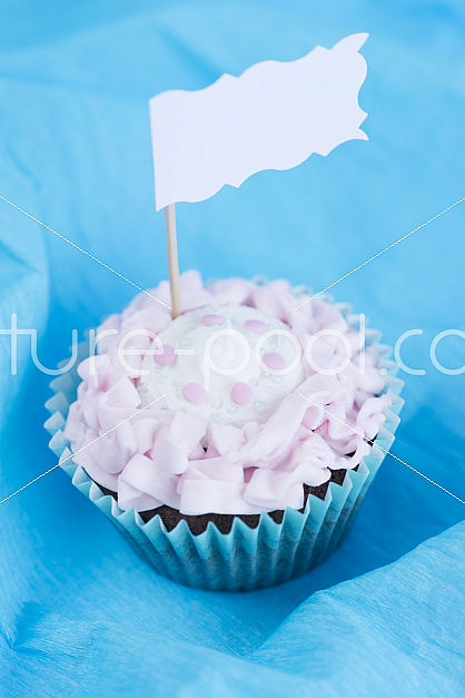Cupcake vor blauem Hintergrund und Fähnchen