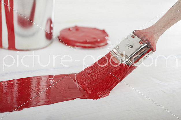 Auiftragen roter Farbe auf weißem Holz