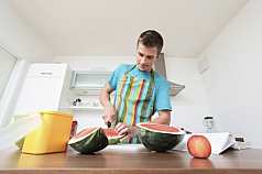 Mann zerkleinert eine Wassermelone