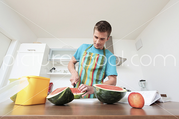 Mann zerkleinert eine Wassermelone
