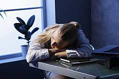 Frau schläft am Arbeitsplatz 