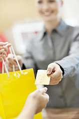 Junge Frau bezahlt Einkauf mit Kreditkarte