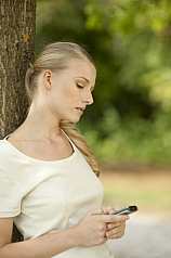 junge Frau liest SMS vom Handy