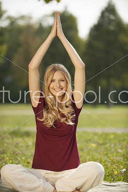 junge blonde Frau macht Joga im Park