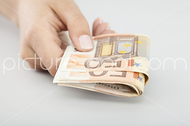 Frauenhand hält 50-Euro-Scheine Frauenhand hält 50-Euro-Scheine