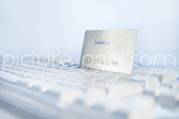 Kreditkarte steckt in Tastatur, Online-Shopping