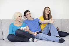 Drei Jugendliche mit Spielekonsole
