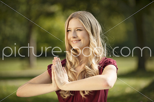 junge blonde Frau macht Joga im Park