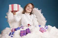 IPTC CAPTION-Field: Kleines Mädchen mit Geschenken als Weihnachtsengel verkleidet
