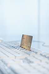 Goldene Kreditkarte steckt in Tastatur, Online-Shopping