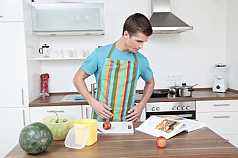 junger Mann in der Küche mit Kochbuch 