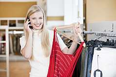 Junge blonde Frau beim shoppen und telefonieren