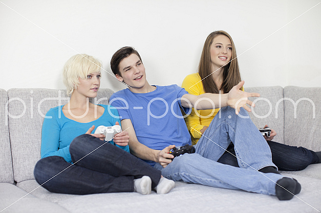 zwei Mädchen und ein Junge beim Computerspielen