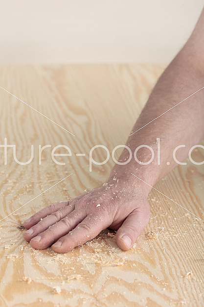 Handwerker Hand mit Sägespäne auf Holzplatte