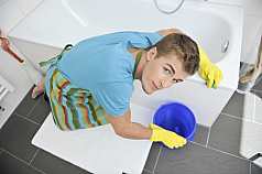 junger Mann putzt Badezimmer 