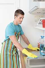 Mann putzt Küche 