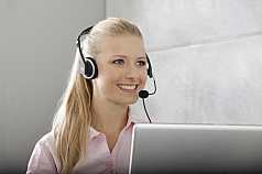 junge Frau mit Laptop und Headset