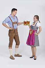 Junges Pärchen in Dirndl und Lederhose trinken Bier