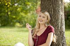 junge blonde Frau hört Musik