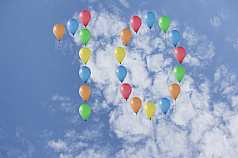 Jubiläumszahl 10 aus Luftballons vor Wolken